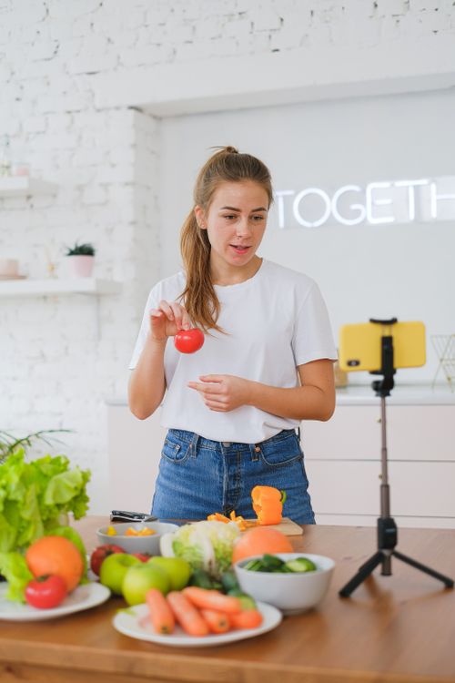 A food creator filming a recipe with her phone
